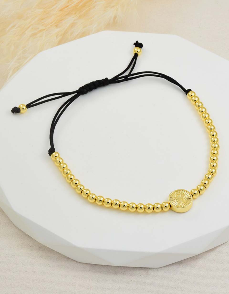 Pulsera con medalla y esferas doradas