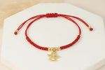 Manilla con dije de ángel en tejido rojo